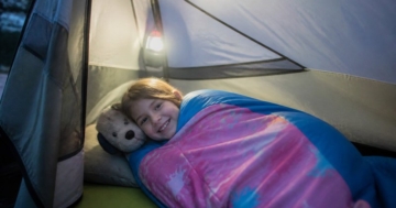 Kind im Schlafsack im Zelt