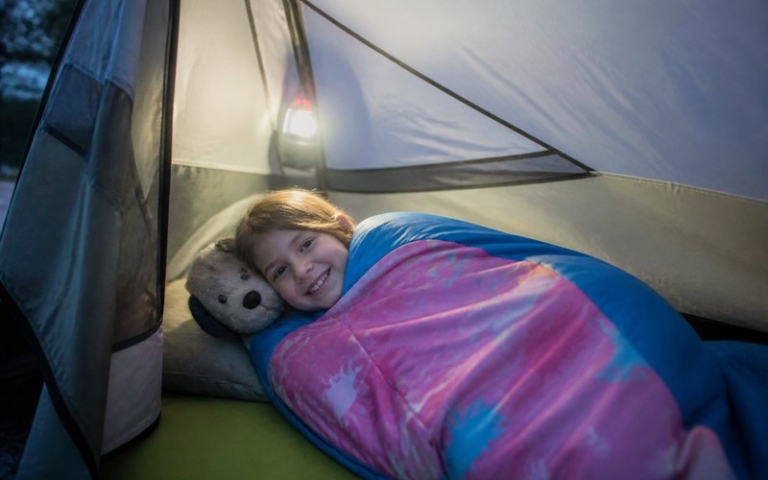 Kind im Schlafsack im Zelt
