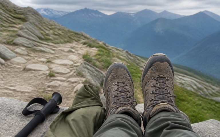 Getragene Wanderschuhe bei einer Rast auf einem Bergpfad